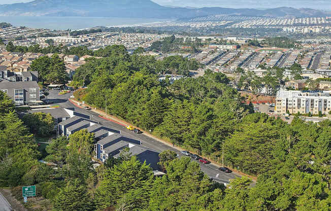 A road with cars on it and trees on the side.