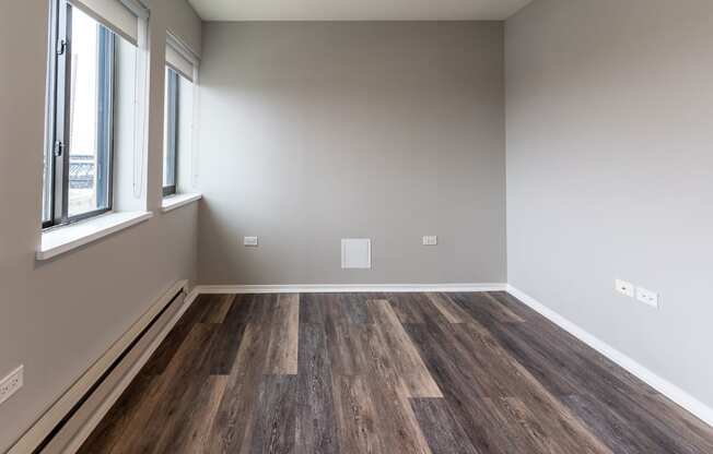 an empty room with wood flooring and a window