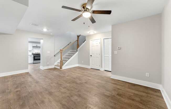 Living room with a staircase and a ceiling fan at Crogman School Lofts, Atlanta, 30315