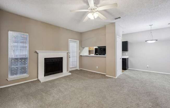 A living room with a fireplace and a ceiling fan.