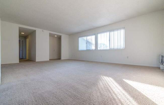 an empty living room with a large window at Park Avenue Apartments, Long Beach, California