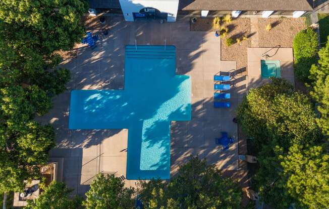 an aerial view of a swimming pool with a blue cross on it