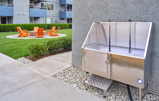 a stainless steel dog wash station sits on the side of a sidewalk in front of an apartment building  at 3030 Lake City, Seattle