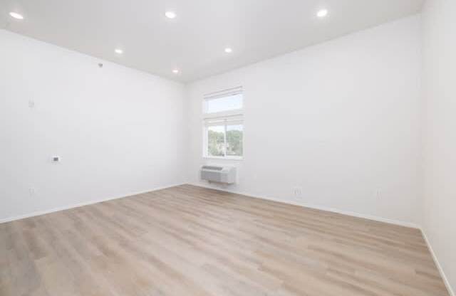 A room with wooden flooring and a window.