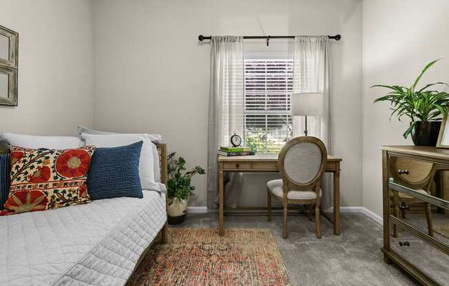 bedroom with a bed and a desk with a chair and a window