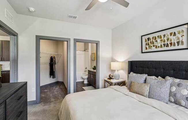 A bedroom with a large bed and a ceiling fan.