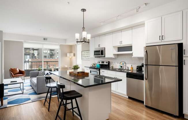 a kitchen with stainless steel appliances and a island with three stools
