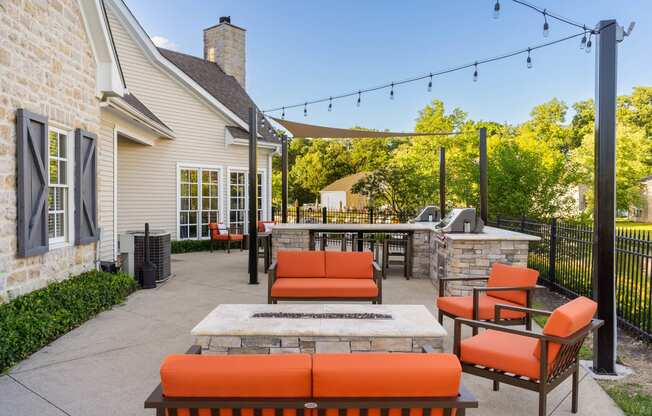 a patio with orange furniture and a stone fireplace