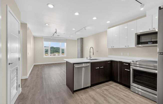 A modern kitchen with stainless steel appliances and wooden floors.