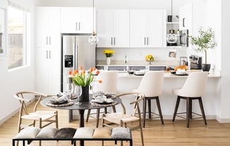 a kitchen and dining area with a table and chairs and a refrigerator