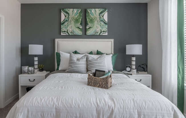 a bedroom with a white bed and two paintings on the wall