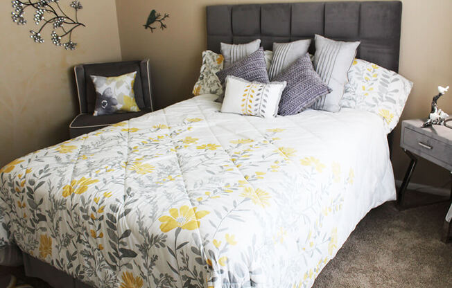 a bedroom with a large bed with a white and yellow comforter and pillows