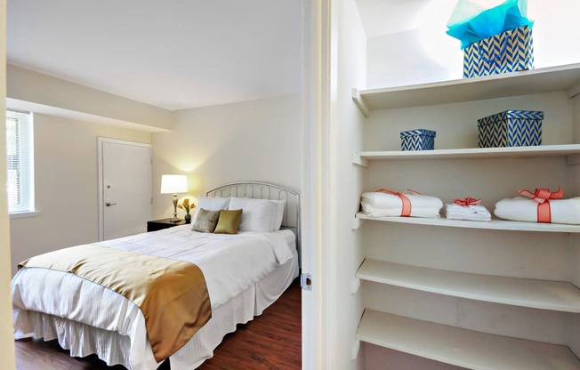 A bedroom with a bed and a closet with shelves.