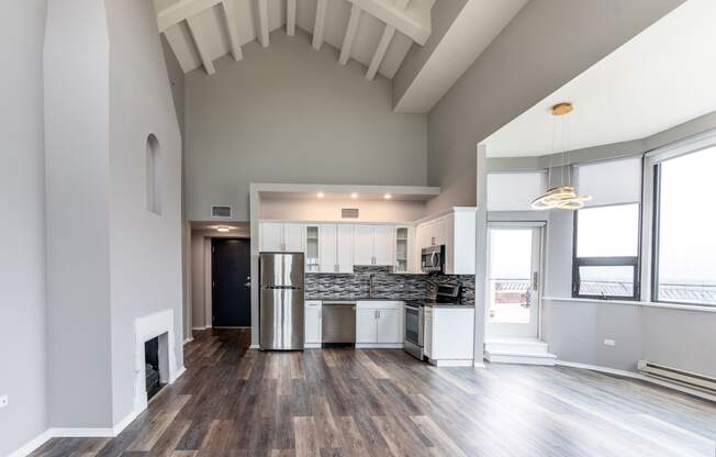 a living room with a kitchen and a large window