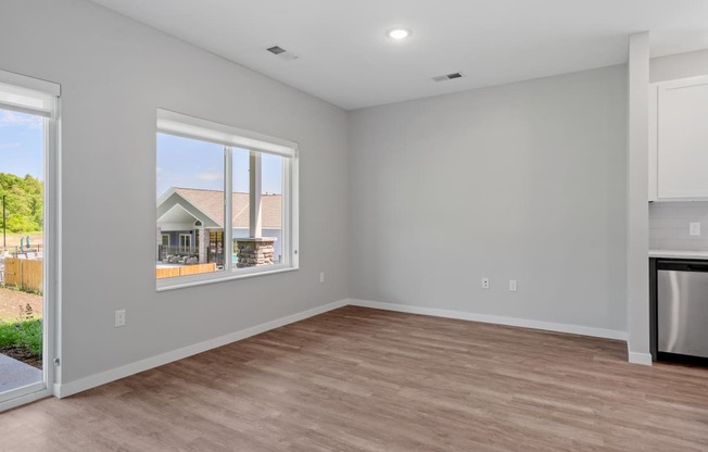 a bedroom with a large window and hardwood floors at The Lodge at Overland, Rochester, MN, 55901