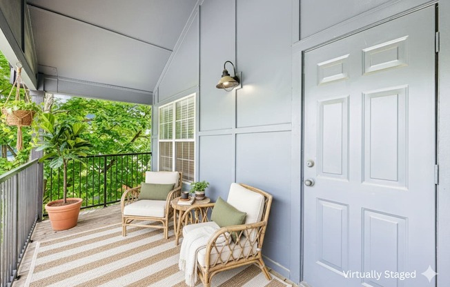 A patio with a white door and a striped rug.