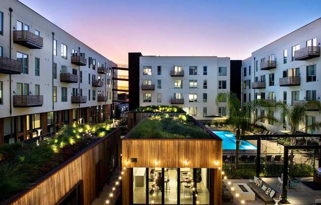 A modern building with a green roof and a pool.