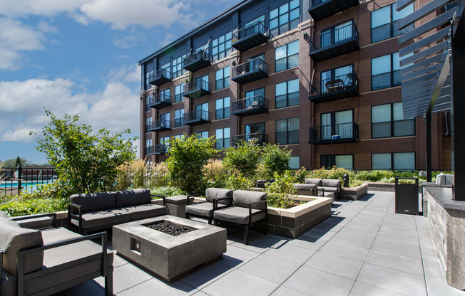 an outdoor patio with a firepit and seating