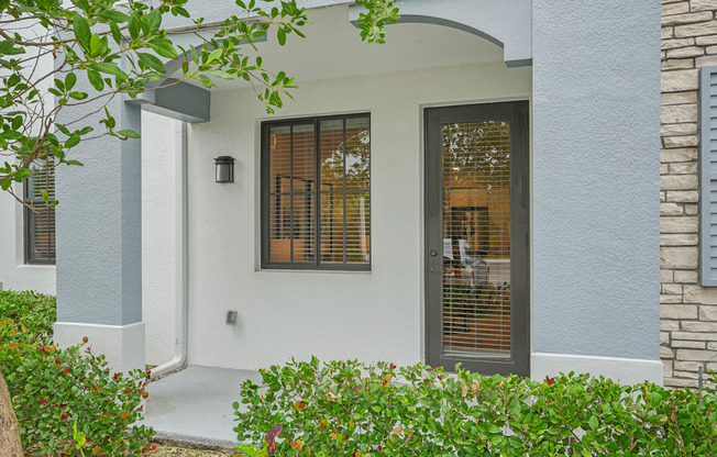 the front entrance of a house with a door and windows