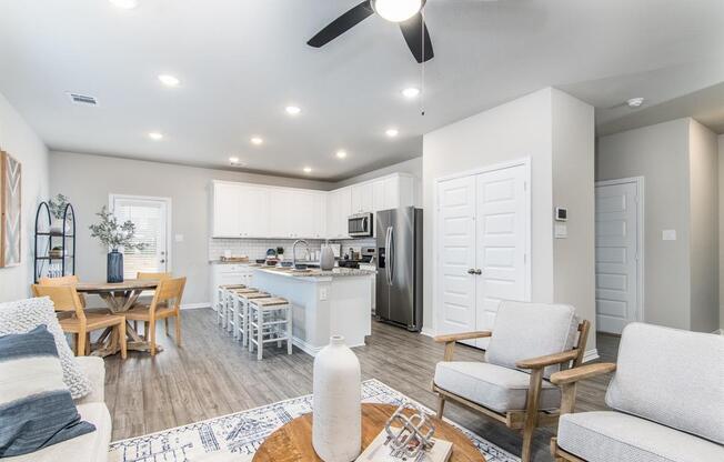 a living room and kitchen area with a ceiling fan
