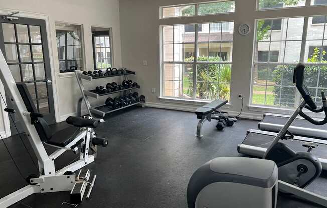 a gym with weights and other exercise equipment and windows