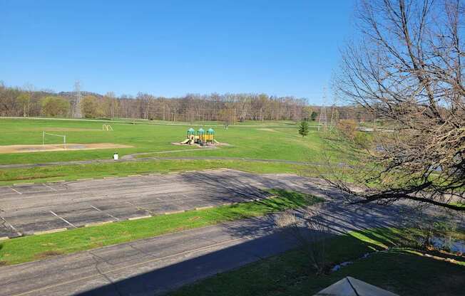 A park with a playground and a paved area.