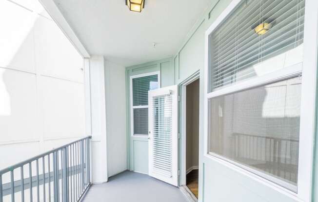 a view of a hallway with a door and a balcony