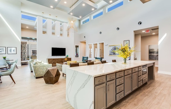 a kitchen with a large center island next to a living room with a couch and a fireplace