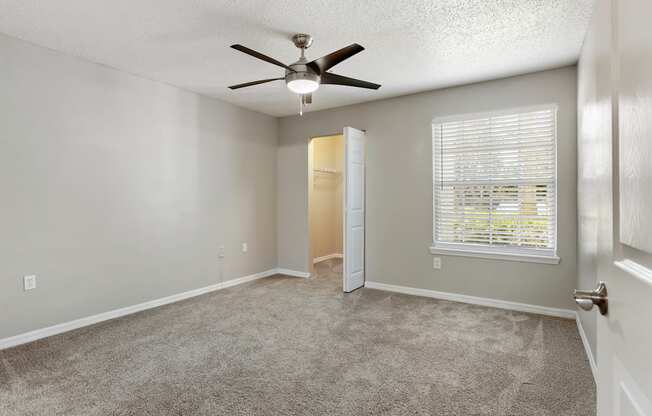 Model bedroom with carpet and and a ceiling fan at Hunters Green in Tampa, Florida.