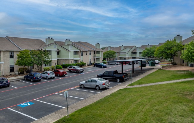 a parking lot filled with cars in front of houses