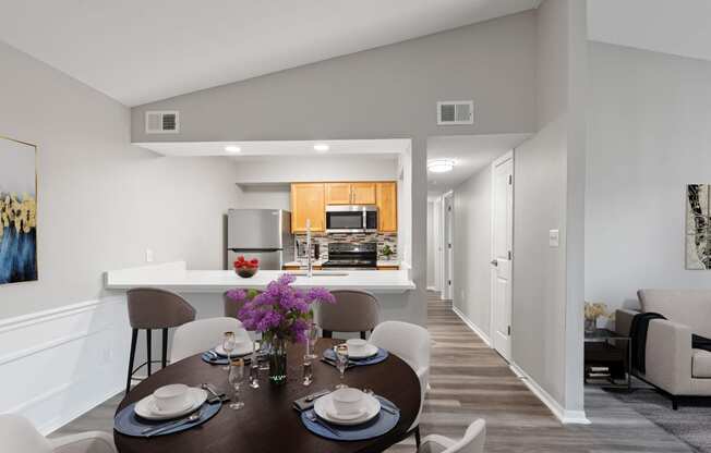 a dining room and kitchen area with a table and chairs