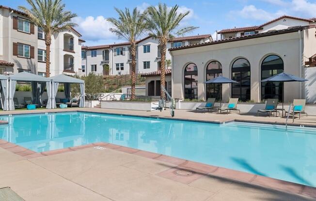a swimming pool with chairs and umbrellas at Arrive Temecula