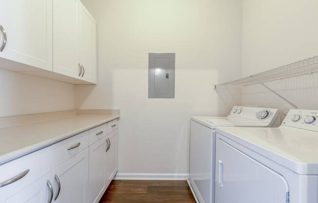 a laundry room with white cabinets and a washer and dryer