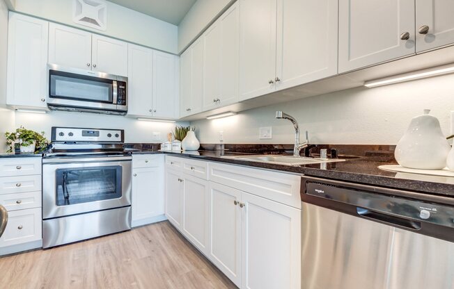 Upland Oakland, CA Apartments for Rent - Rowhaus Apartments Kitchen with Stainless Steel Appliances and Modern Light Fixtures