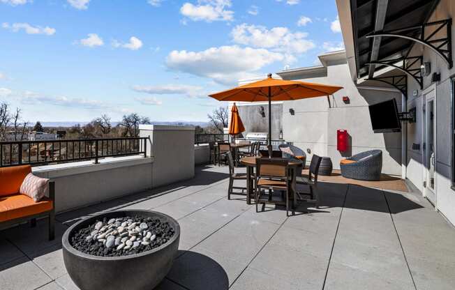 a patio with tables and chairs and a fire pit at Alton Jefferson Park, Denver Colorado