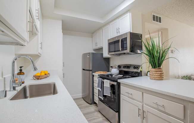 a kitchen with white cabinets and stainless steel appliances