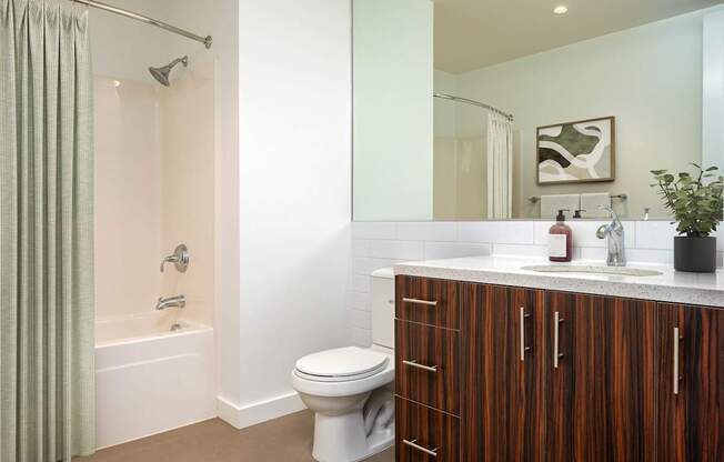 A bathroom with a toilet, sink, and shower.