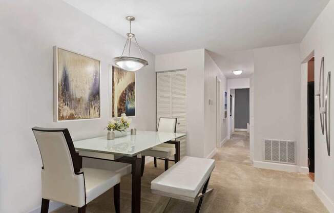 A dining room with a glass table and chairs.