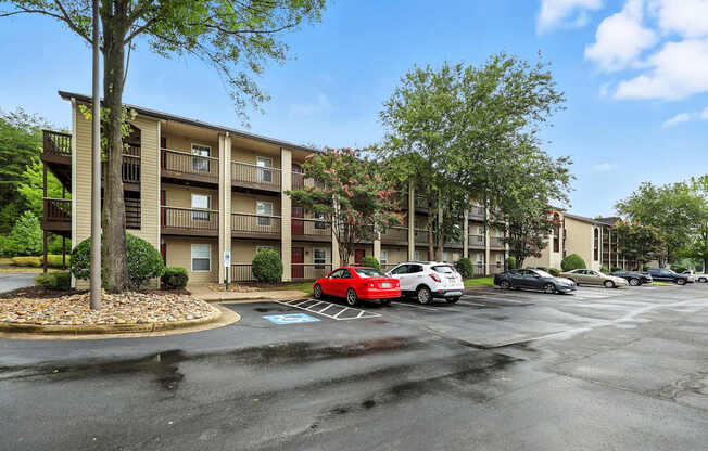 A parking lot with cars and apartment buildings in the background.