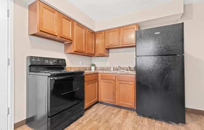 a kitchen with black appliances and wooden cabinets