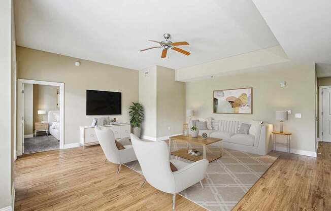 A living room with a white sofa and a wooden floor.