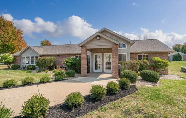 a brick house with a driveway and landscaped yard