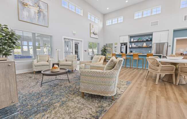 a living room with couches and chairs and a kitchen with a table