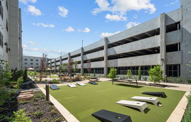 a courtyard with picnic tables and grass in front of an office building