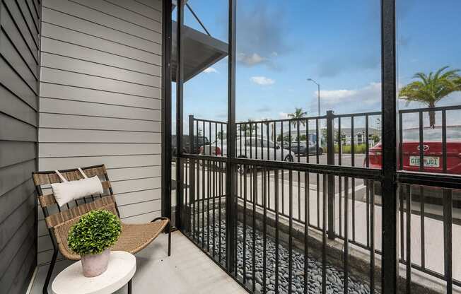 a balcony with a chair and a view of a parking lot