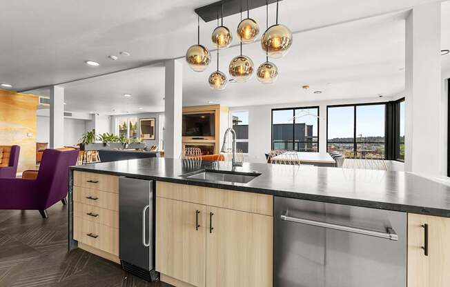 A modern kitchen with a purple chair and a view of the outdoors.