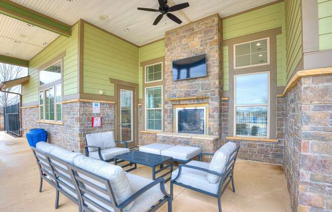 a patio with chairs and a fireplace