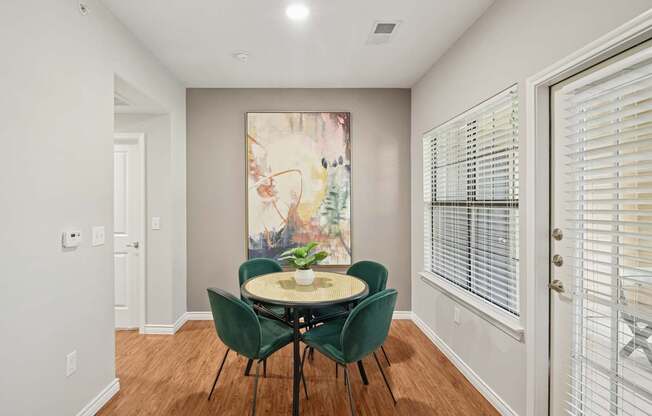 A dining room with a table and chairs.