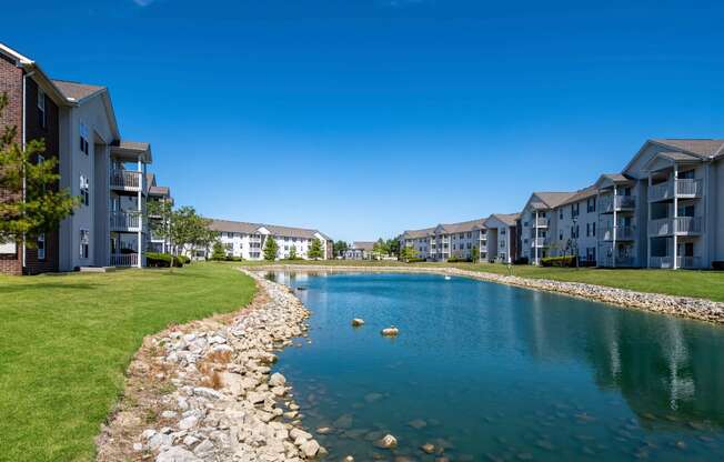 a large pond with apartment buildings on the other side of it