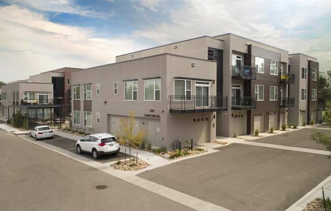 a new apartment building with cars parked in front of it
